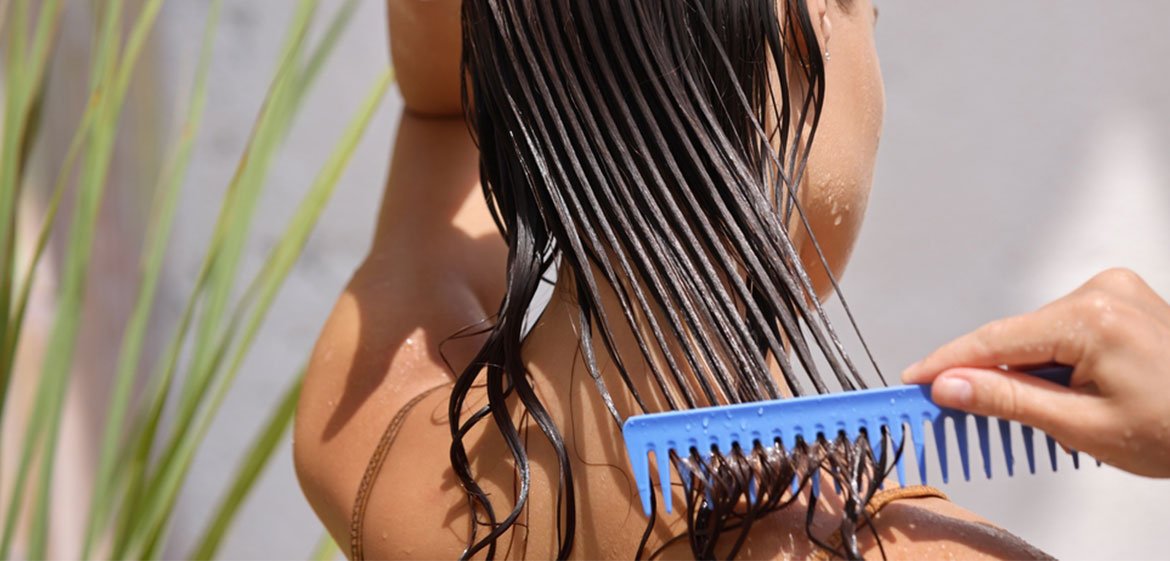 Eine junge Frau kämmt sich ihre langen, nassen Haare